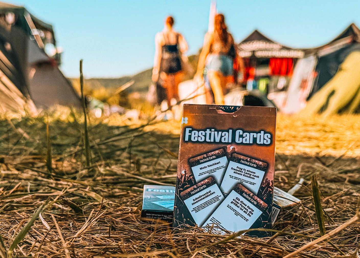 Aufgefächerte Spielkarten auf einem Holztisch neben Festivalbändchen